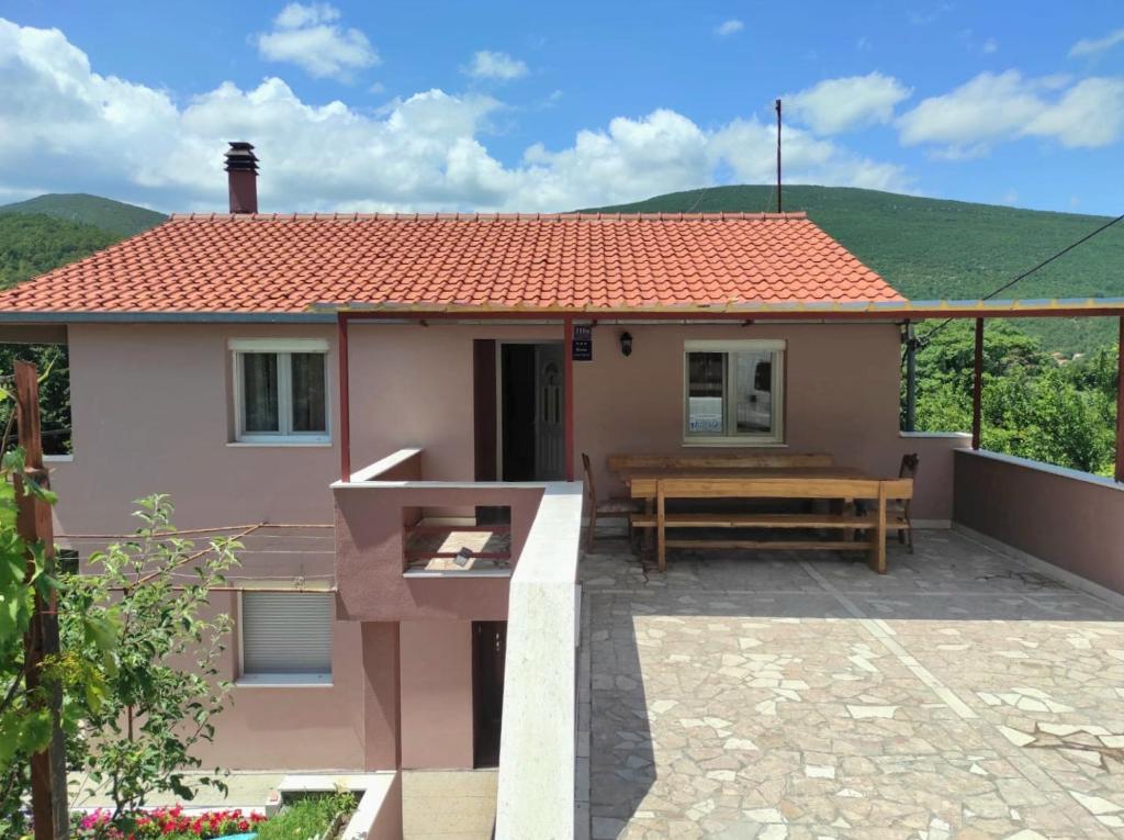 ein kleines Haus mit einer Bank auf einer Terrasse in der Unterkunft Apartman Neva in Sinj