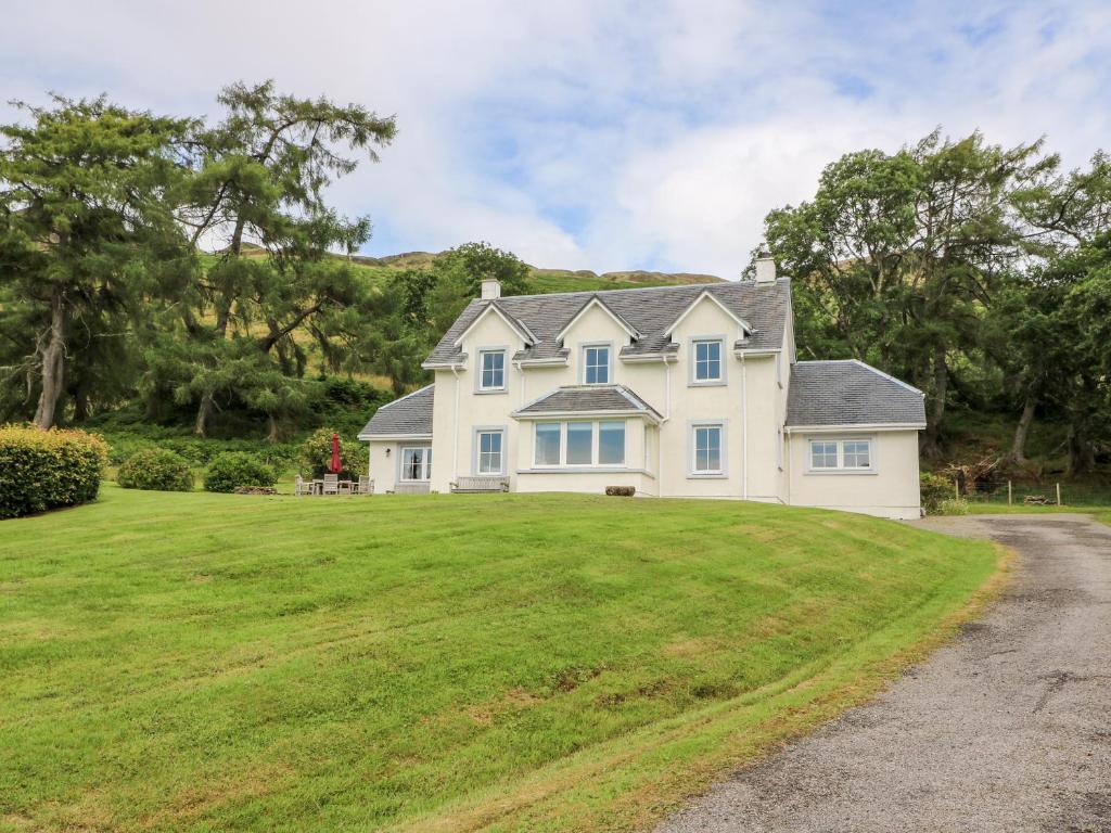 una grande casa bianca con un ampio cortile di Fearnach Bay House a Oban