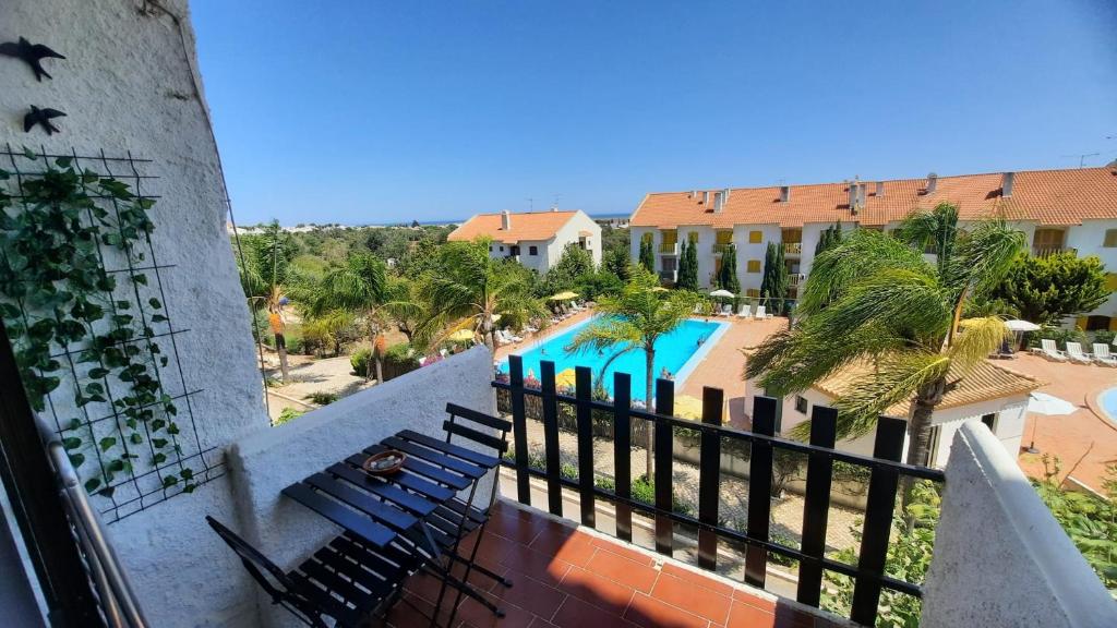 a balcony view of a resort with chairs and a pool at Nora Velha T0+1 em Tavira in Tavira