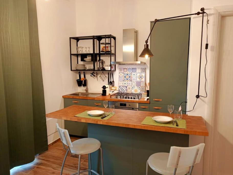 une cuisine avec un comptoir avec deux chaises et un comptoir dans l'établissement Appartamento Olivo, à Collecorvino