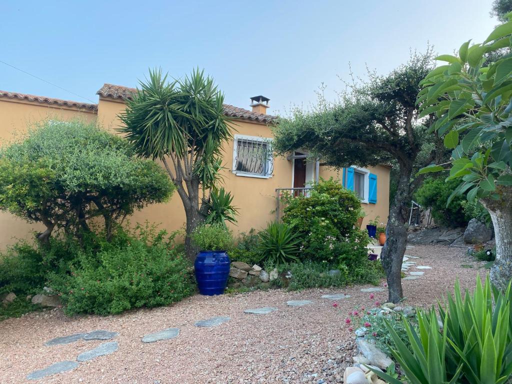 une maison jaune avec des arbres devant une cour dans l'établissement VILLA LARGIA porto vecchio - A 5 MIN DES PLAGES DE PALOMBAGGIA - CALME- CLIMATISATION, à Porto-Vecchio