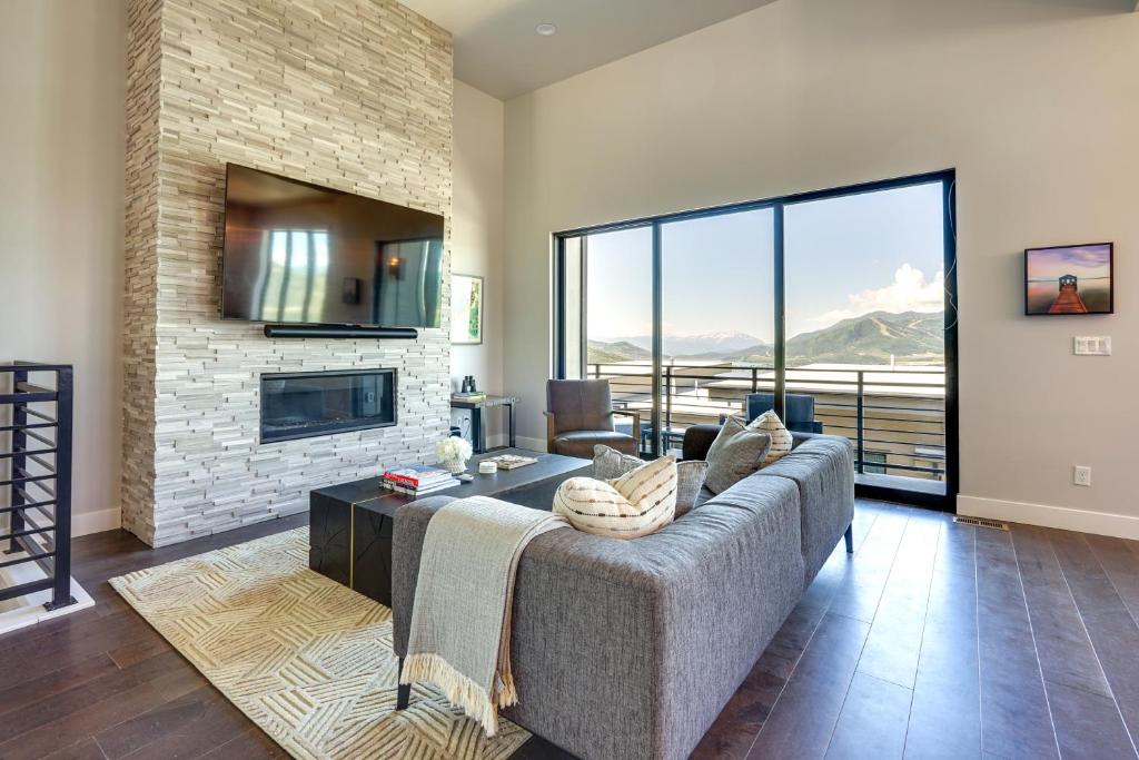 a living room with a couch and a fireplace at Hideout Haven Luxe Retreat with Lake View and Hot Tub in Keetley