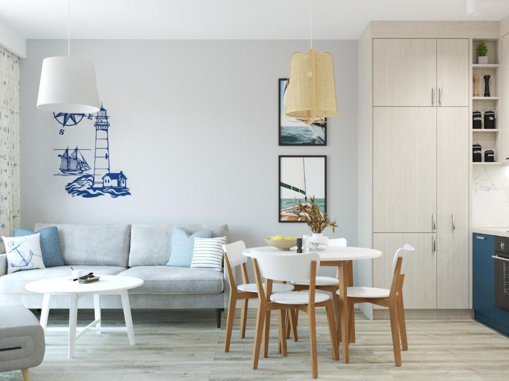 a living room with a couch and a table and chairs at Stacja Baltic Twins in Sztutowo
