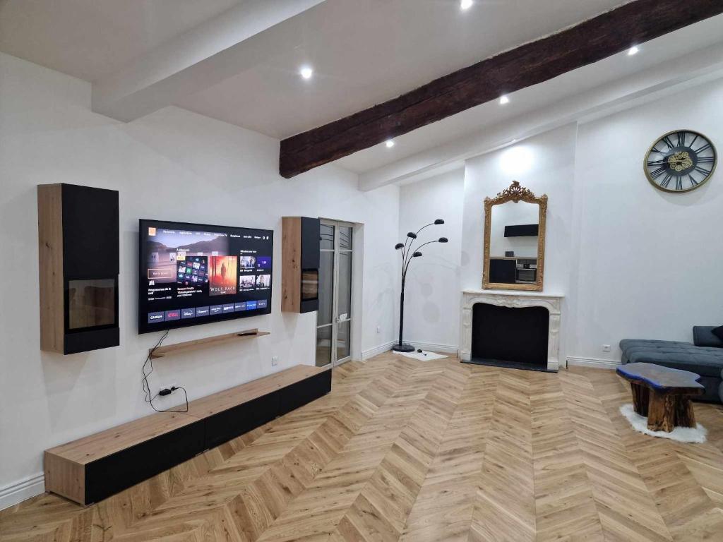 uma sala de estar com uma televisão de ecrã plano na parede em Royal Univers Appart' em Bessan