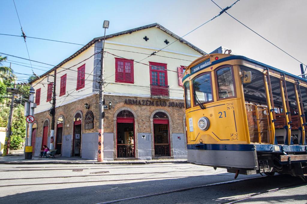 un tranvía amarillo en una calle frente a un edificio en Lobie Armazém São Joaquim en Río de Janeiro