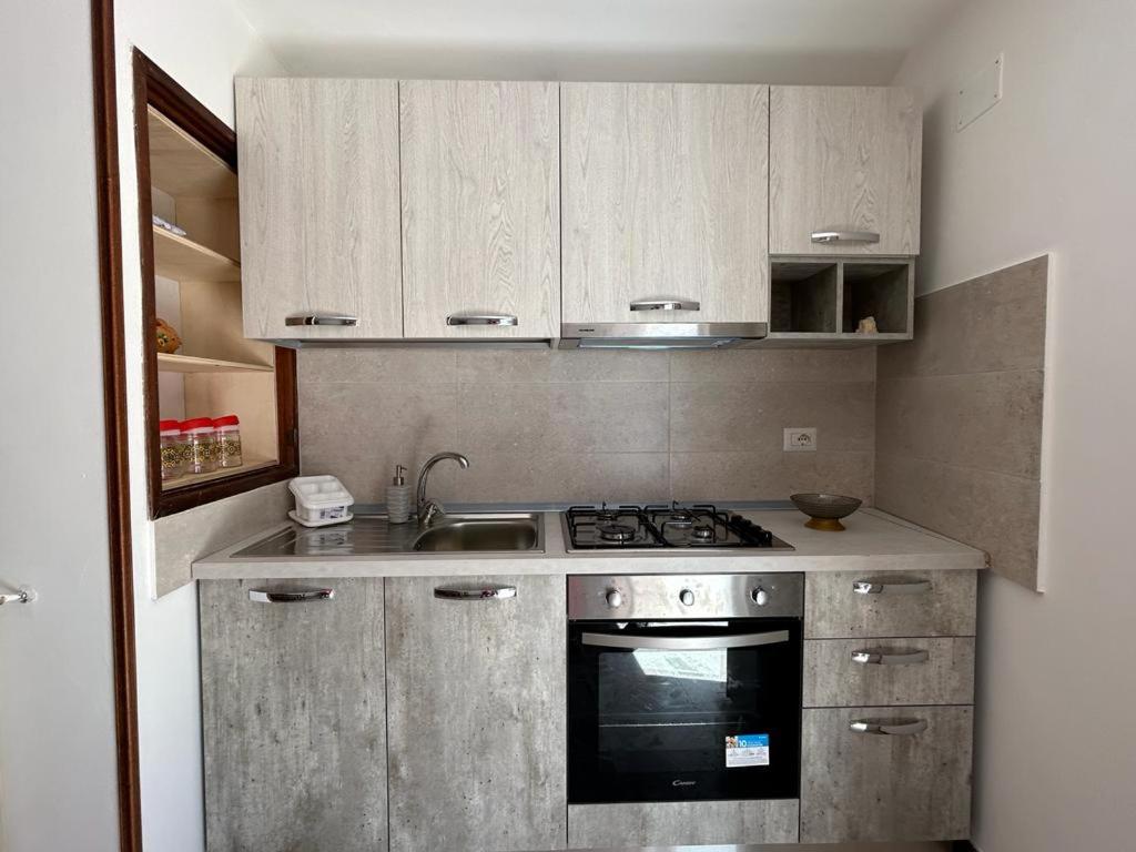 a small kitchen with a stove and a sink at La terrazza sui Nebrodi in Mistretta