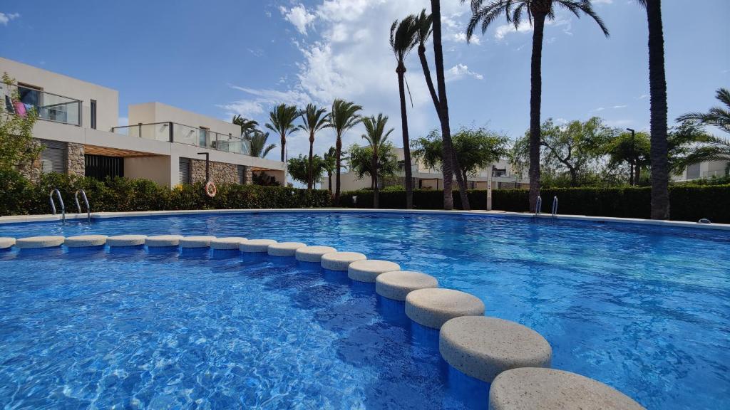 una piscina con palme e un edificio di PARADISE premium apartment a Villajoyosa