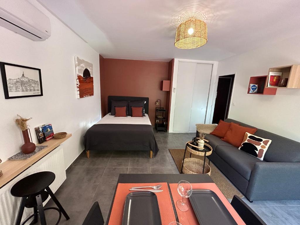 uma sala de estar com um sofá e uma cama em Les Appartements d'Edmond Rome Favier em Marselha