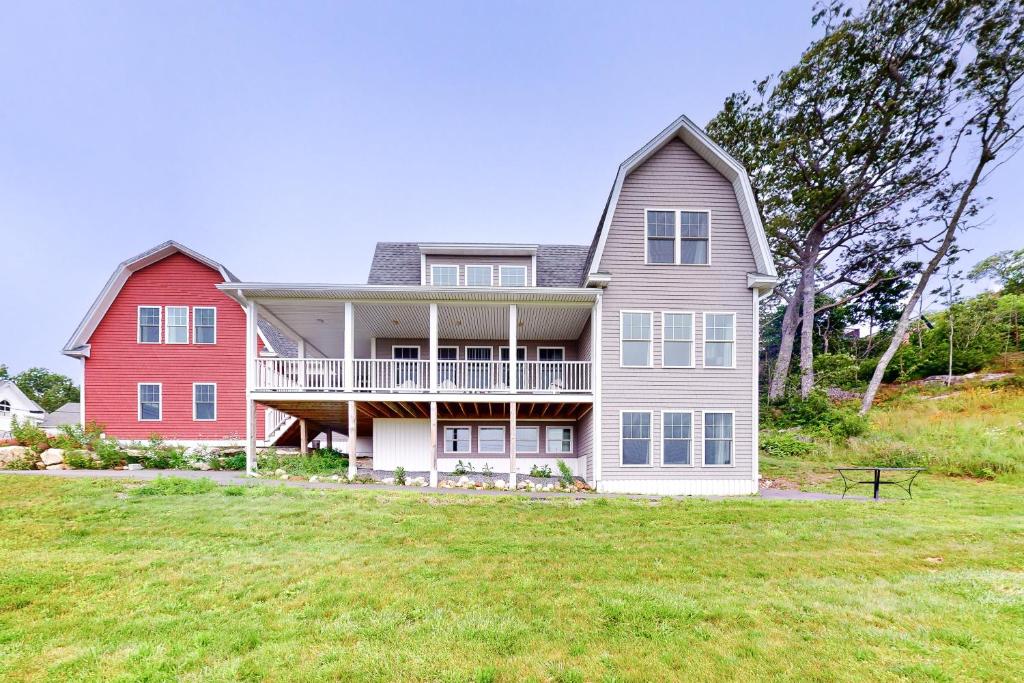 ein großes Haus auf einem Hügel mit einem Grasfeld in der Unterkunft Mill Pond Suite in East Boothbay