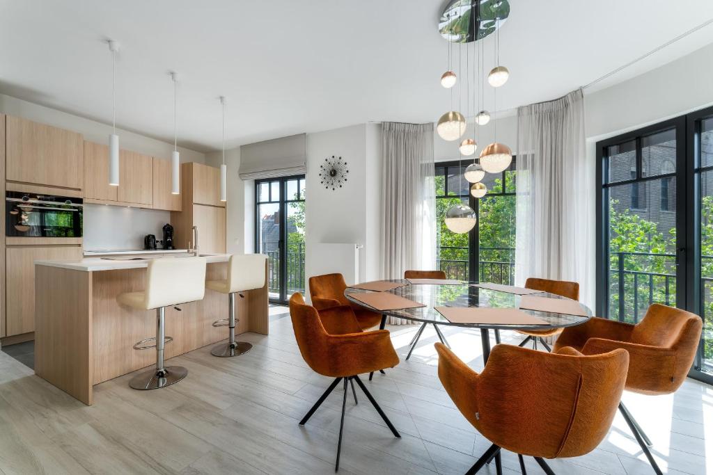 een keuken en eetkamer met een glazen tafel en stoelen bij Zonnig Luxueuze Appartementen La Coronne in Knokke-Heist