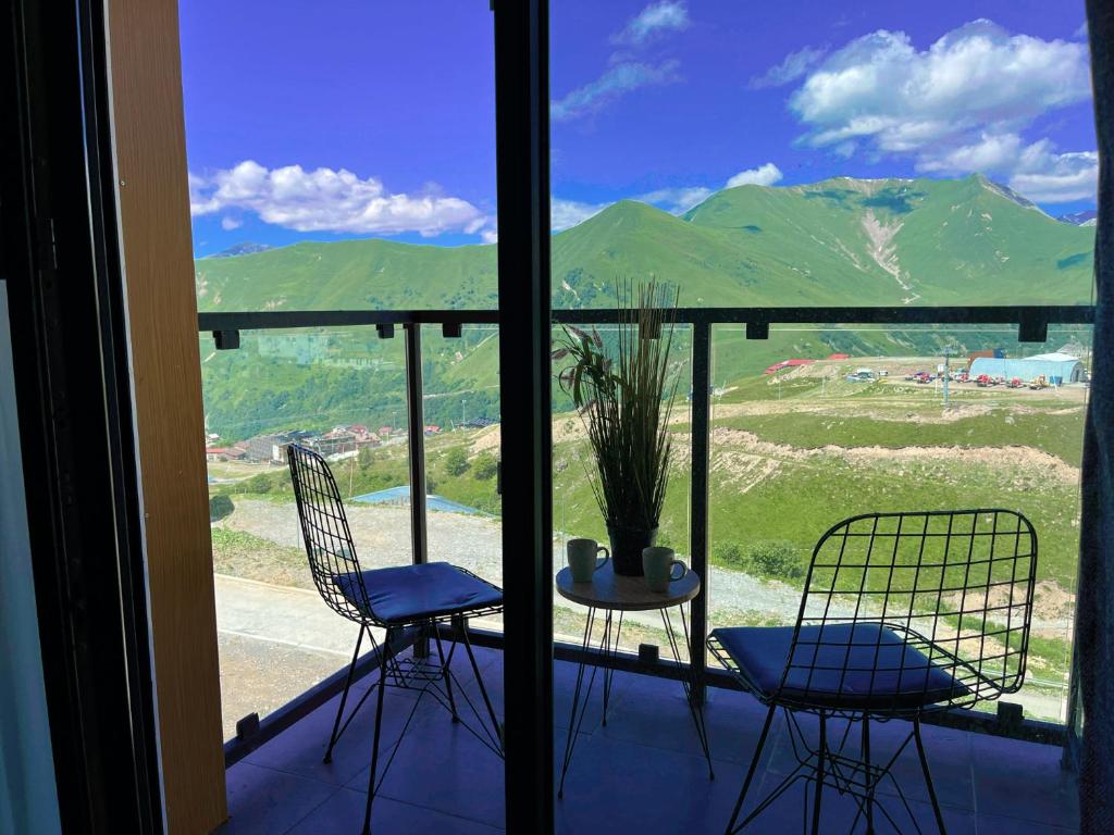 two chairs and a table on a balcony with a view of mountains at Delux apartment for 6 guest, new gudauri in Gudauri