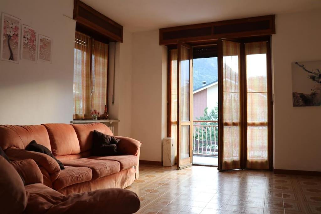 sala de estar con sofá y puerta abierta en Oasi verde Susa città, en Susa