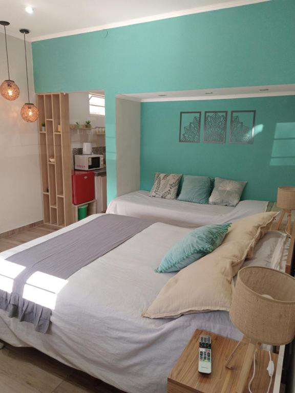 1 dormitorio con 1 cama grande y pared azul en Departamentos pura vida 2 en General Roca