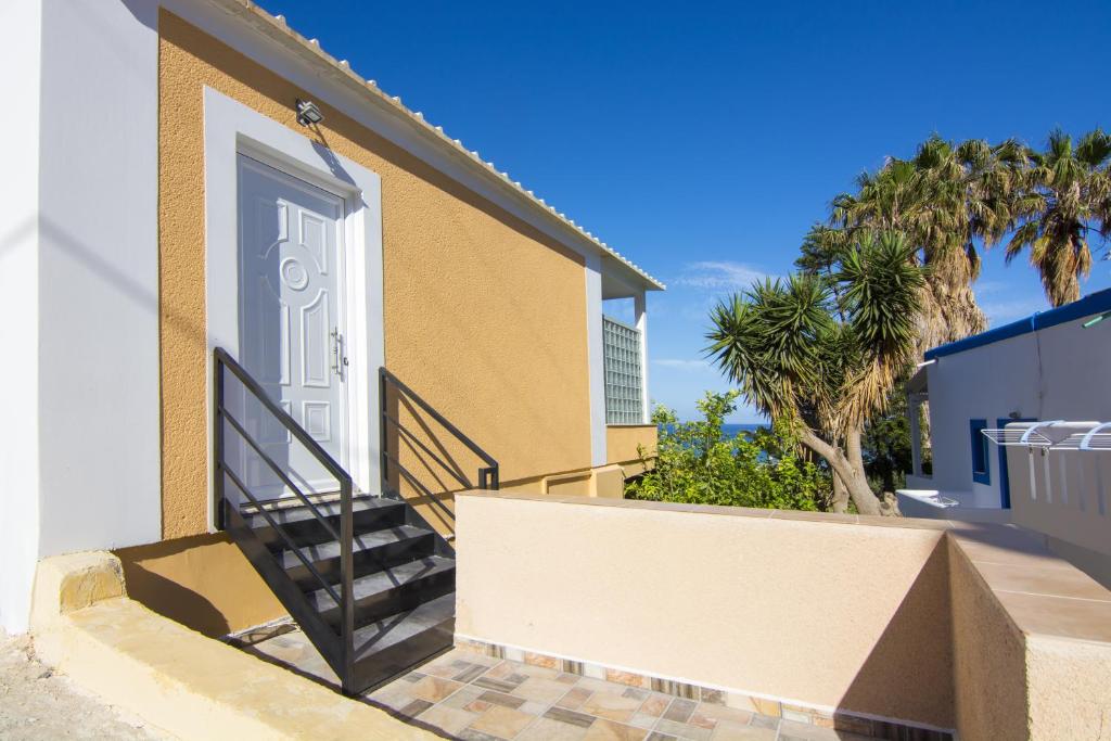a house with a white door and stairs at Villa Giorgos in Kefalos