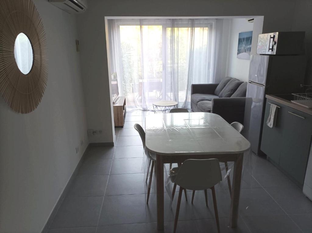 Il dispose d'une cuisine et d'un salon avec une table et un canapé. dans l'établissement Charmant studio dans la résidence Haut du Golf, à Valescure