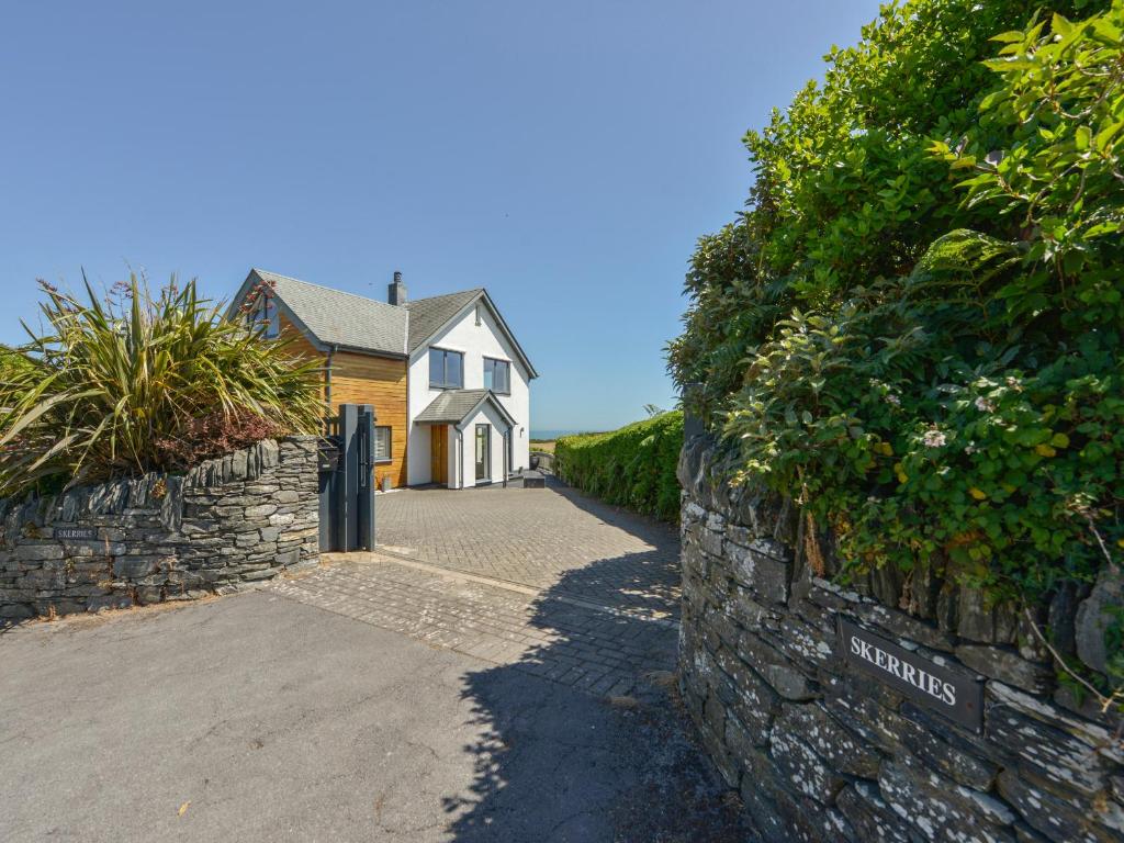 a house with a stone wall next to a street at Skerries in Dartmouth