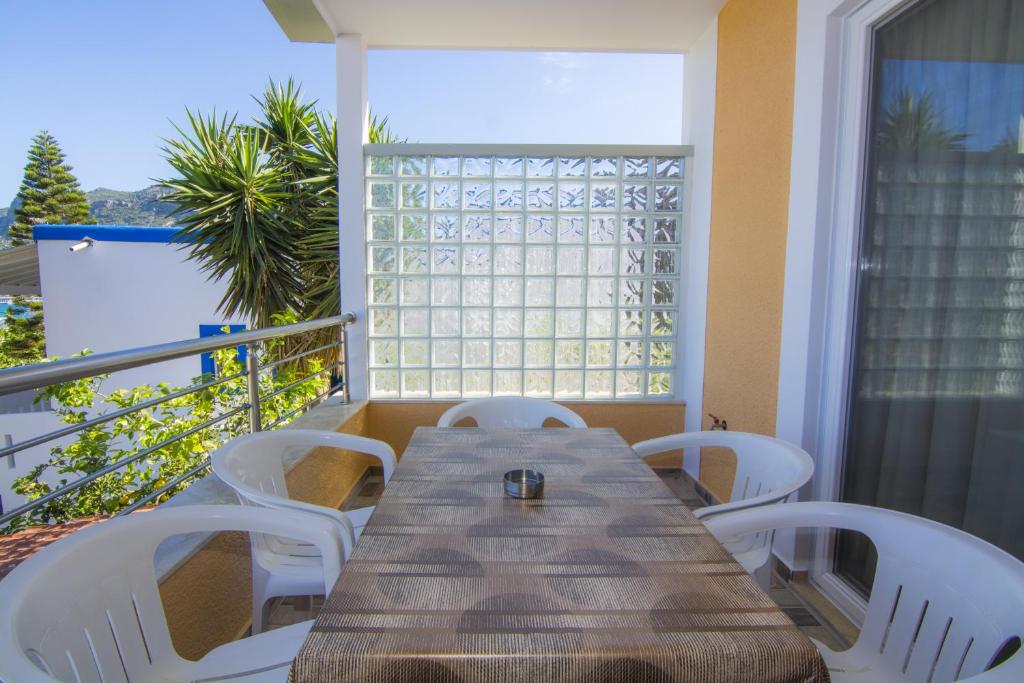 a wooden table and white chairs on a balcony at Villa Giorgos in Kefalos