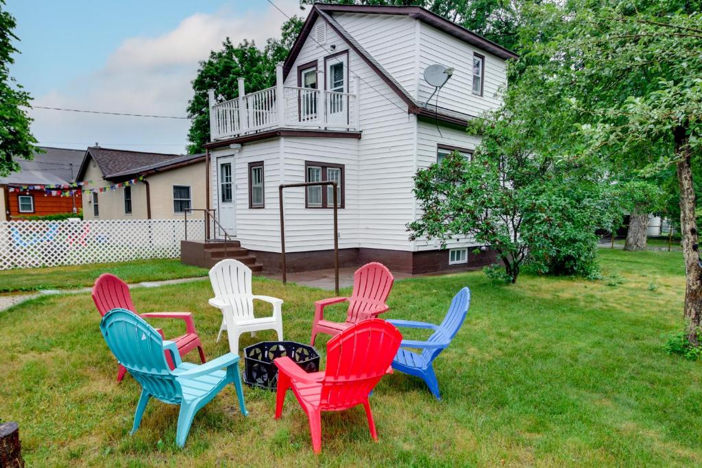 a group of chairs sitting in the grass in front of a house at Mtn Bikers Cottage Bike to Cuyuna Lakes Trails in Crosby