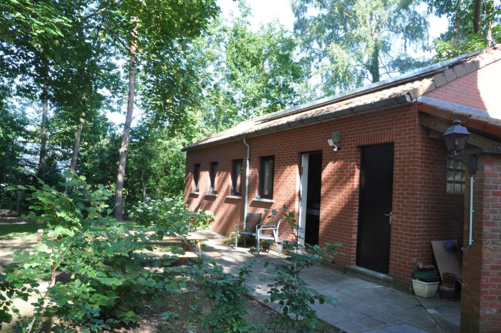 a red brick building with a patio and trees at Van Horick in Baal