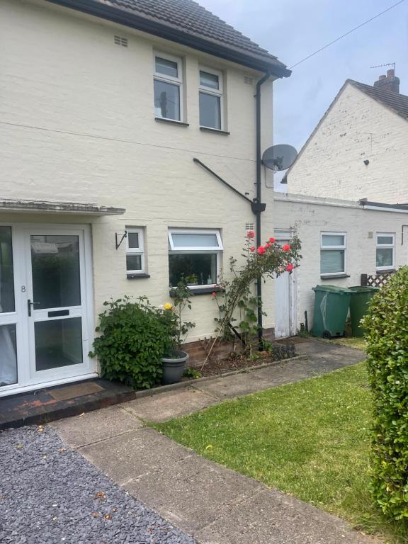 a white house with a window and a yard at House number 8 sleeps up to 6 People with Smart TVs in Every Room in Wellington