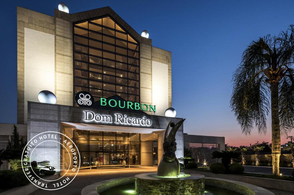 um edifício com uma estátua em frente em Bourbon Dom Ricardo Aeroporto Curitiba Business Hotel em São José dos Pinhais