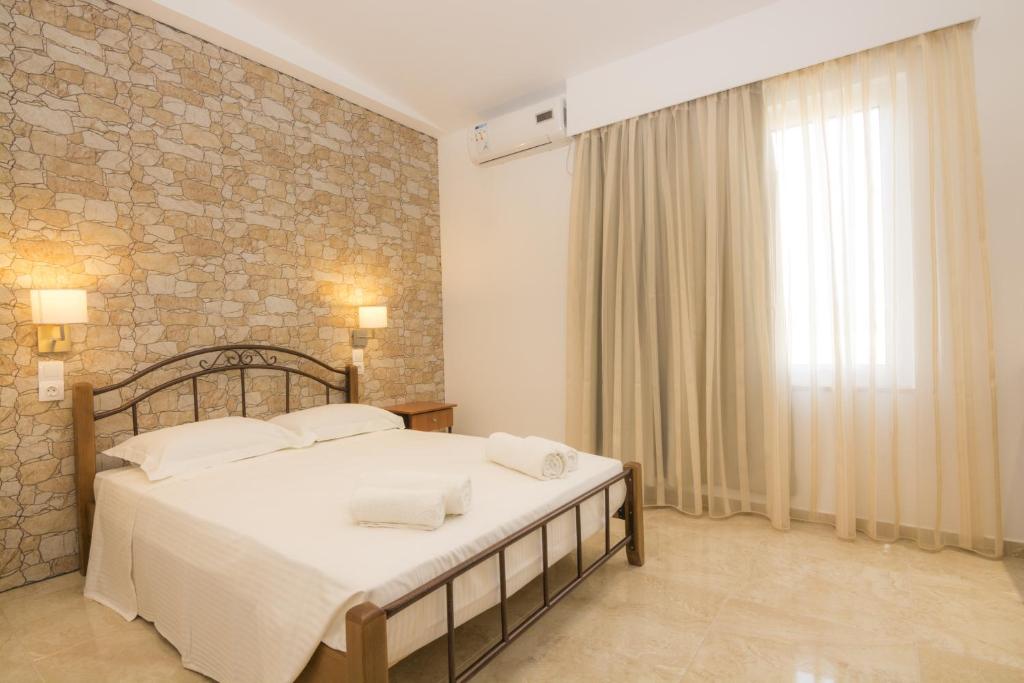 a bedroom with a large bed and a brick wall at Villa Giorgos in Kefalos