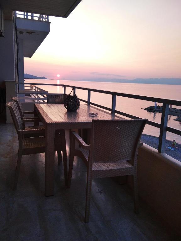 a table and chairs on a balcony with a view of the ocean at SKY AND SEA APARTMENT in Xylokastro