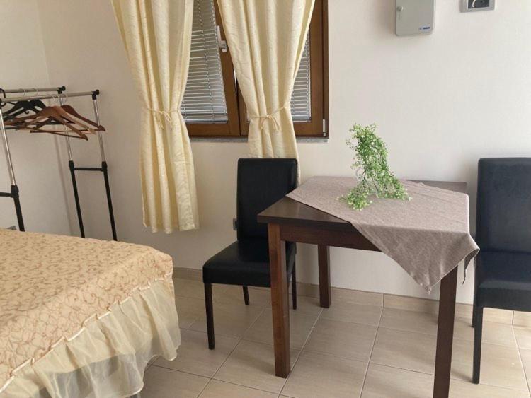 um quarto com uma mesa, 2 cadeiras e uma janela em Экономичная студия с тенистым патио вблизи пляжа em Kotor