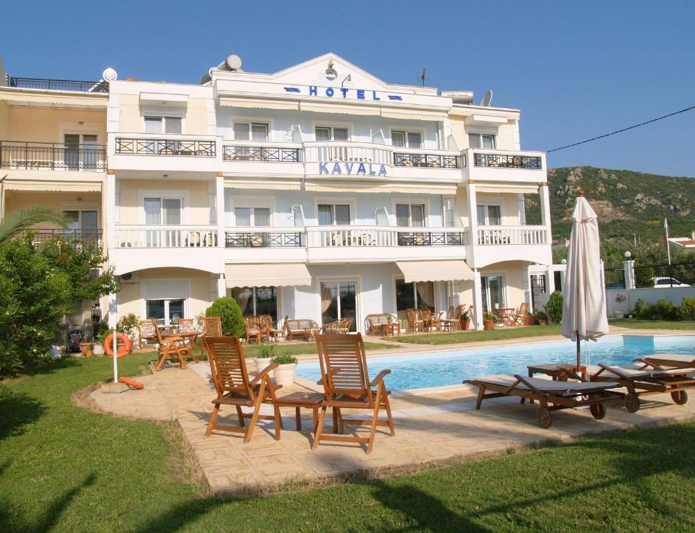 ein Hotel mit Stühlen und einem Pool davor in der Unterkunft Kavala Beach Hotel apartments in Nea Iraklitsa