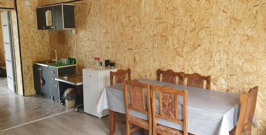 ein Esszimmer mit einem Tisch und Stühlen sowie einem Kühlschrank in der Unterkunft Afrodita Hotel in Stepanawan