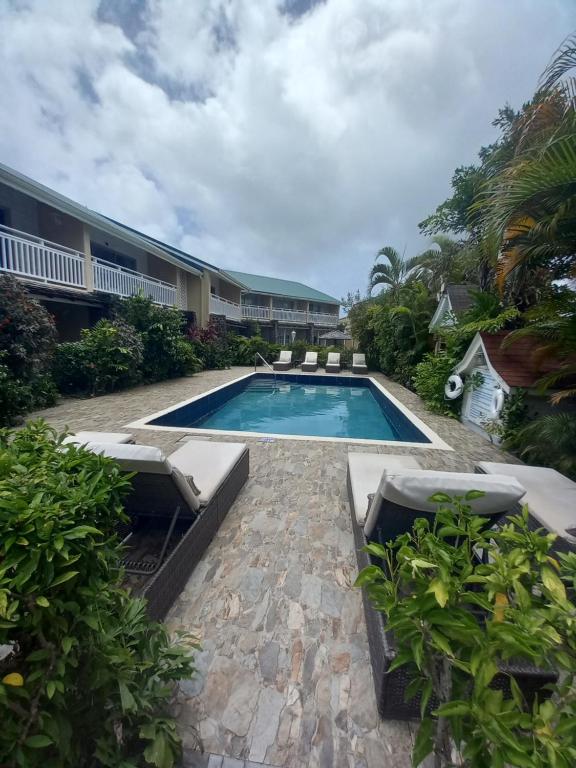 einem Pool mit Liegestühlen und einem Resort in der Unterkunft Harmony Marina Suites in Rodney Bay Village