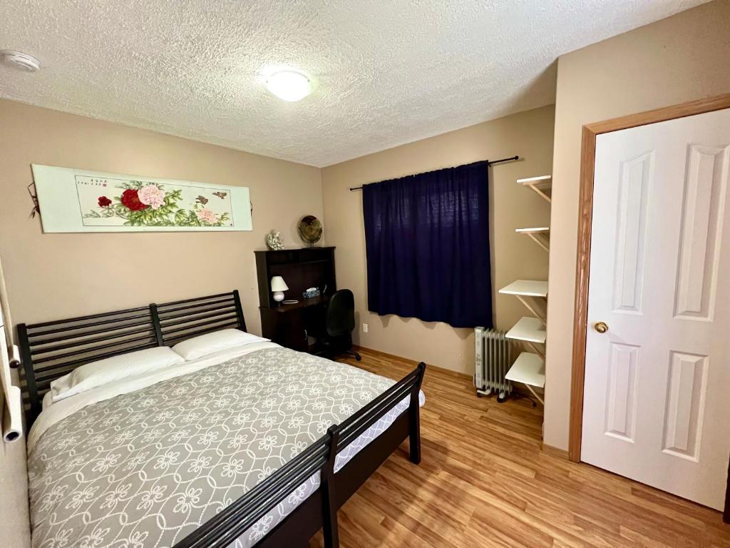 1 dormitorio con cama y ventana azul en Garden and Parkview Sweet Home, en Calgary