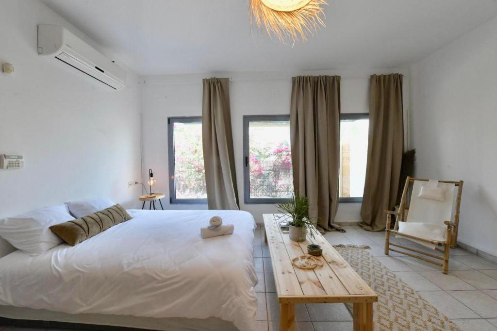 um quarto com uma grande cama branca e uma mesa de madeira em Exotic Shanty Villa Casa Mia em Eilat