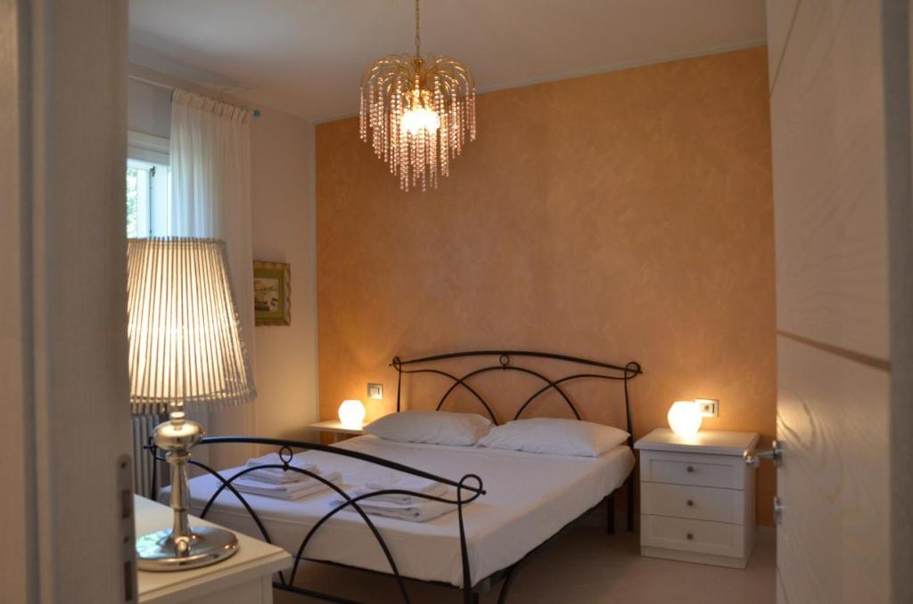een slaapkamer met een bed en een kroonluchter bij Elena Apartment - View Lake - Private Garage in Bardolino