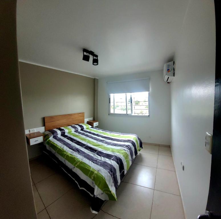 1 dormitorio con 1 cama con edredón a rayas en Zona Alta en San Fernando del Valle de Catamarca