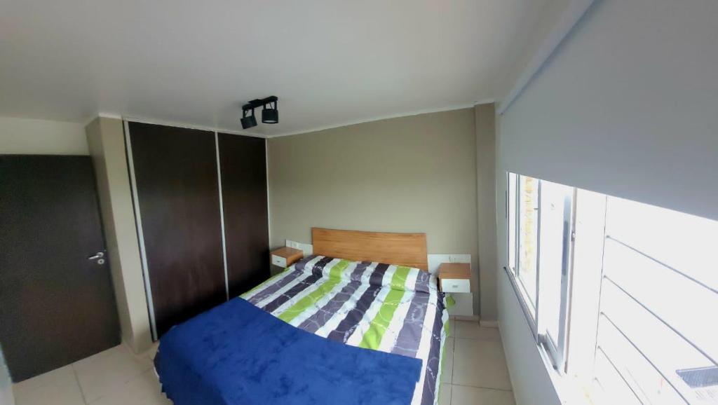 um pequeno quarto com uma cama e uma janela em Zona Alta em San Fernando del Valle de Catamarca