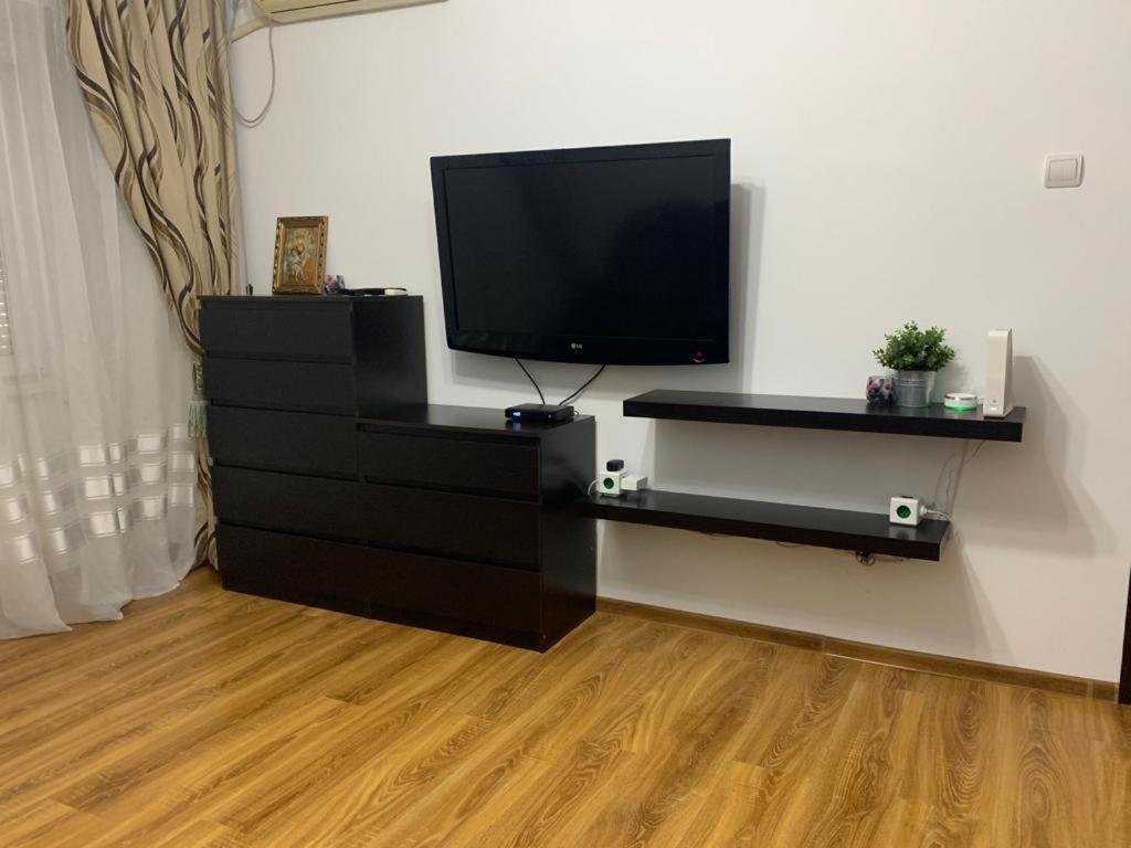 a flat screen tv sitting on top of a black dresser at Alex Apartament in Mangalia