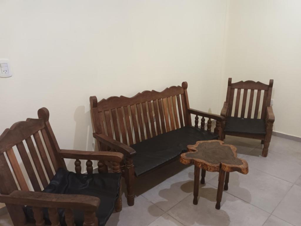 3 sillas de madera y una mesa en una habitación en Don Omar en Posadas