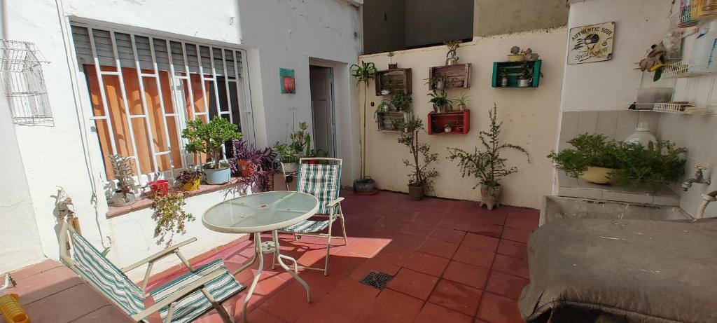 une terrasse avec une table, des chaises et des plantes dans l'établissement Habitación Privada en casa compartida para viajeros, à Córdoba
