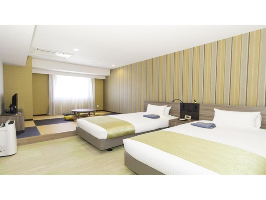 um quarto de hotel com duas camas e uma televisão em La'gent Stay Hakodate Ekimae - Vacation STAY 88790v em Hakodate