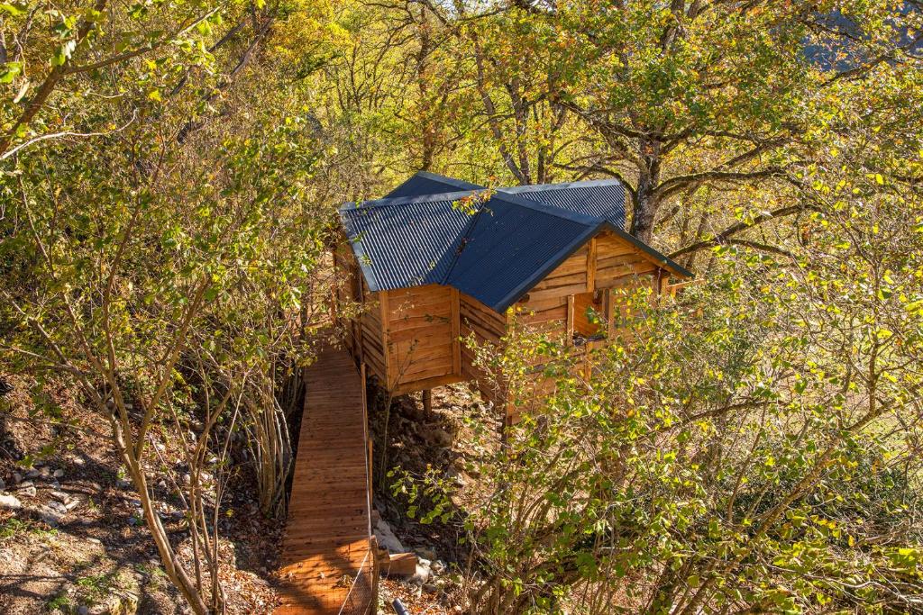 une cabane dans les arbres avec un toit bleu dans les bois dans l'établissement IRATIKO KABIAK, à Orbaiceta