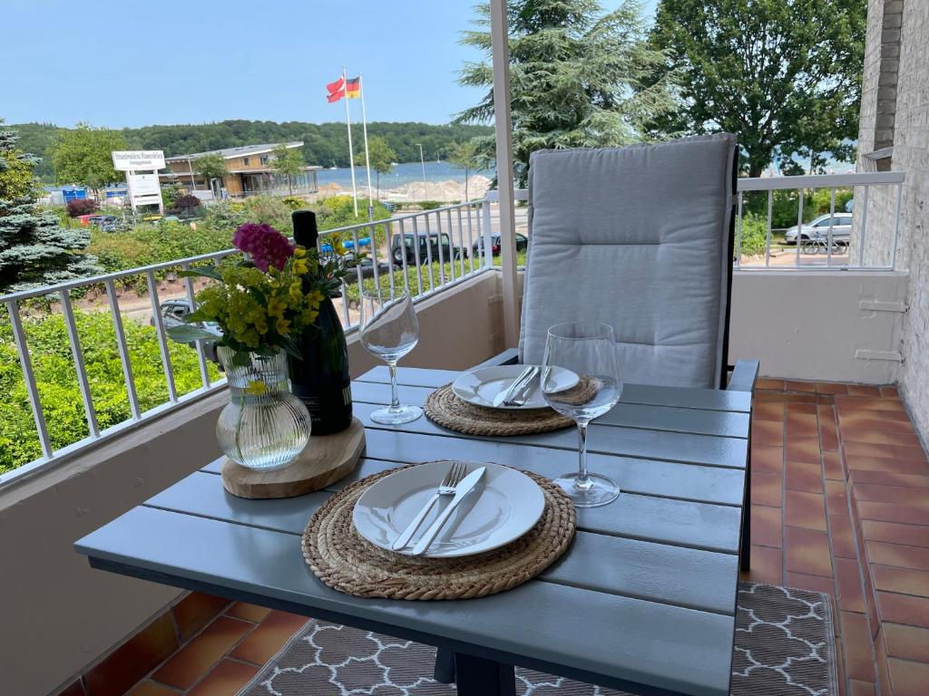 - une table sur un balcon avec des assiettes et des verres à vin dans l'établissement NEU 2023 - Fewo mit Meerblick & Flair, à Harrislee