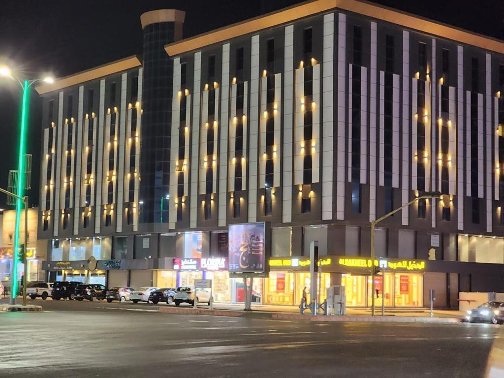 un grand bâtiment avec beaucoup de fenêtres la nuit dans l'établissement المهيدب للوحدات السكنيه -رابغ, à Rabigh