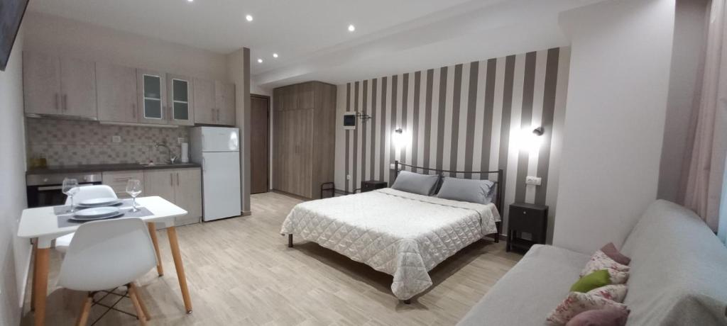 een kleine slaapkamer met een bed en een keuken bij 2downtown.skg in Thessaloniki