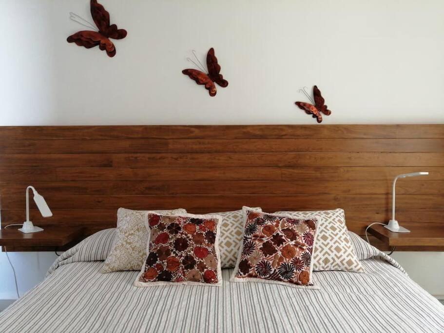 a bedroom with butterflies flying above a bed at Departamento Mariposas in Oaxaca City