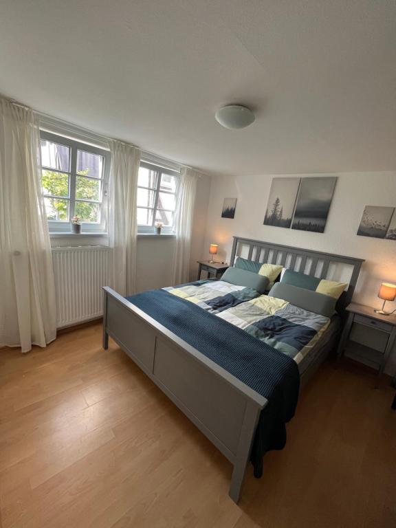 1 cama grande en un dormitorio con 2 ventanas en Fachwerkhäuschen en Melsungen