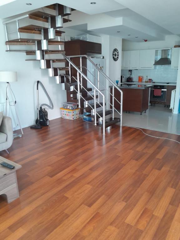 Denize Yakın Daire في أنطاليا: غرفة معيشة مع أرضية خشبية ودرج حلزوني