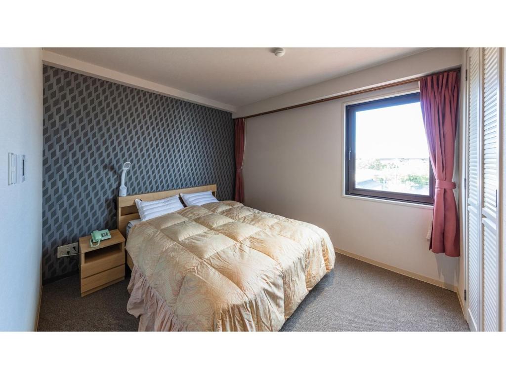 a bedroom with a large bed and a window at Matto Terminal Hotel - Vacation STAY 98884v in Hakusan