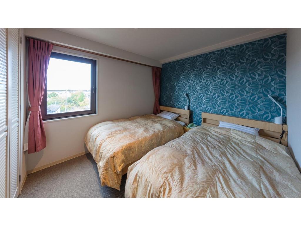 a bedroom with two beds and a window at Matto Terminal Hotel - Vacation STAY 98887v in Hakusan