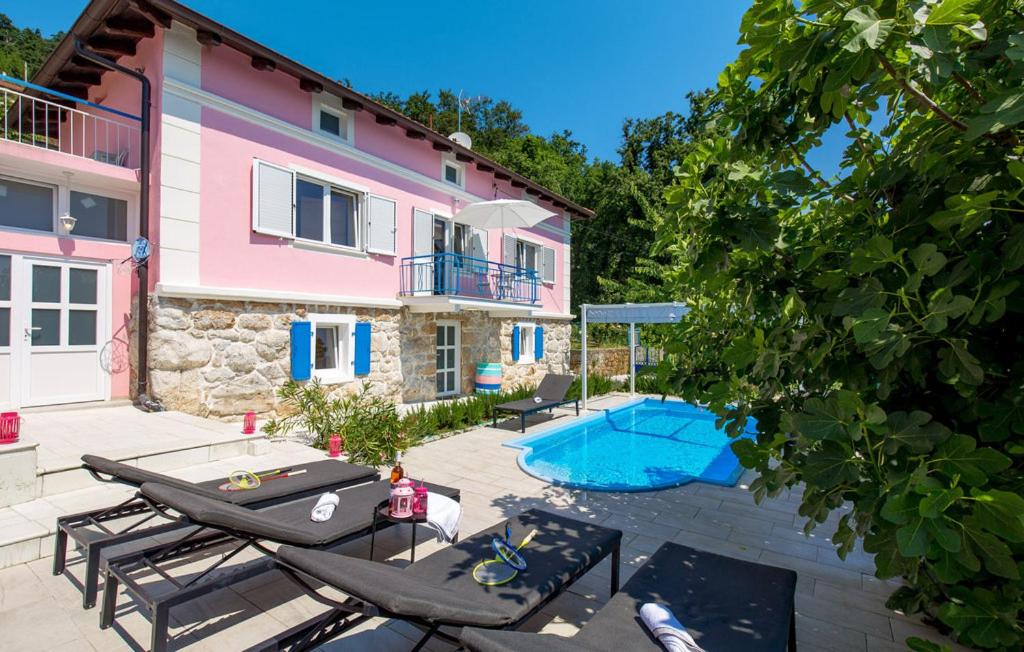 een villa met een zwembad en een huis bij NINA ROSE boutique villa in Lovran